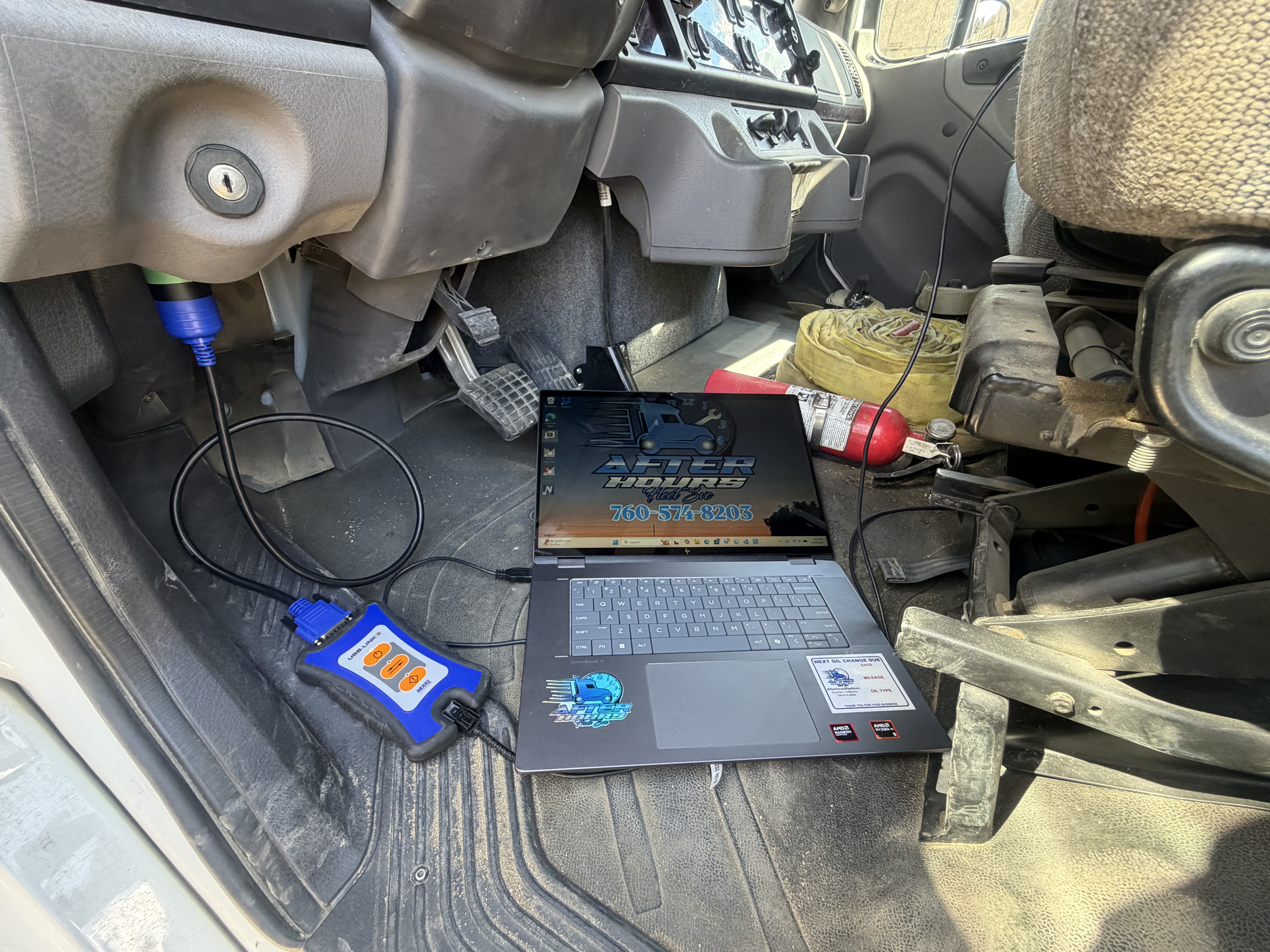 OBD diagnostic tool and laptop connected inside truck cab